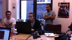 Mark Backler, Theo Chin, and Luc Shelton - Theo Chin, Luc Shelton, and Mark Backler looking suspiciously at a computer screen in a conference room at the UKIE offices in central London.