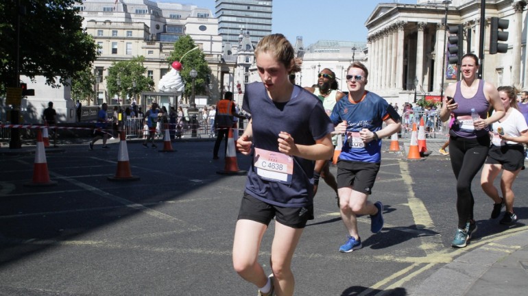 A picture of myself (Luc Shelton) between two other participants, running around the corner on the final stretch of the ASICS London 10K. I am wearing a SpecialEffect jersey.